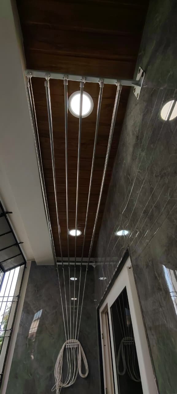Ceiling cloth hanger in a utility area with teak ceiling and green marble wall