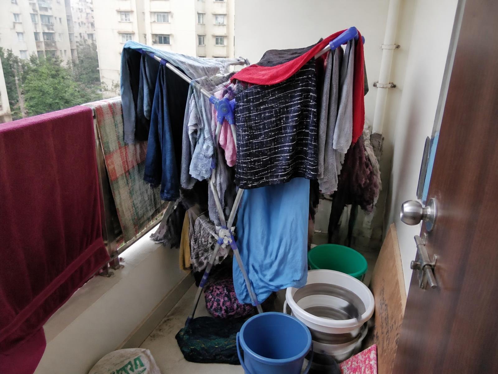 Cluttered apartment balcony with a floor drying stand before installation