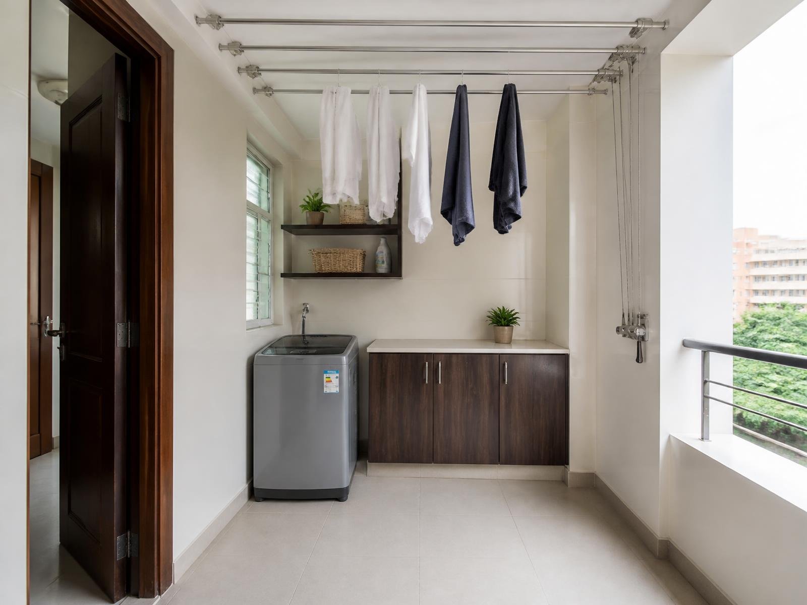 Utility area with a ceiling mounted pulley cloth drying hanger above the washing machine