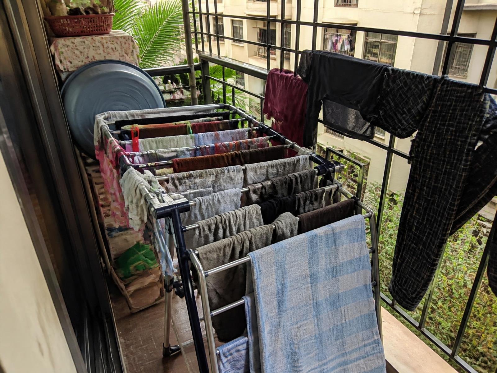 Small narrow balcony crowded with a drying rack before installation