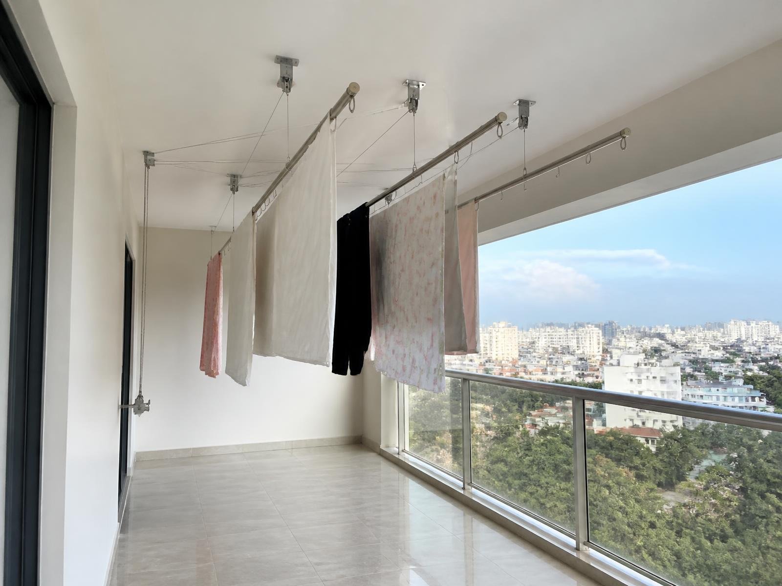 Large balcony with two ceiling mounted cloth drying hangers and clear walking space