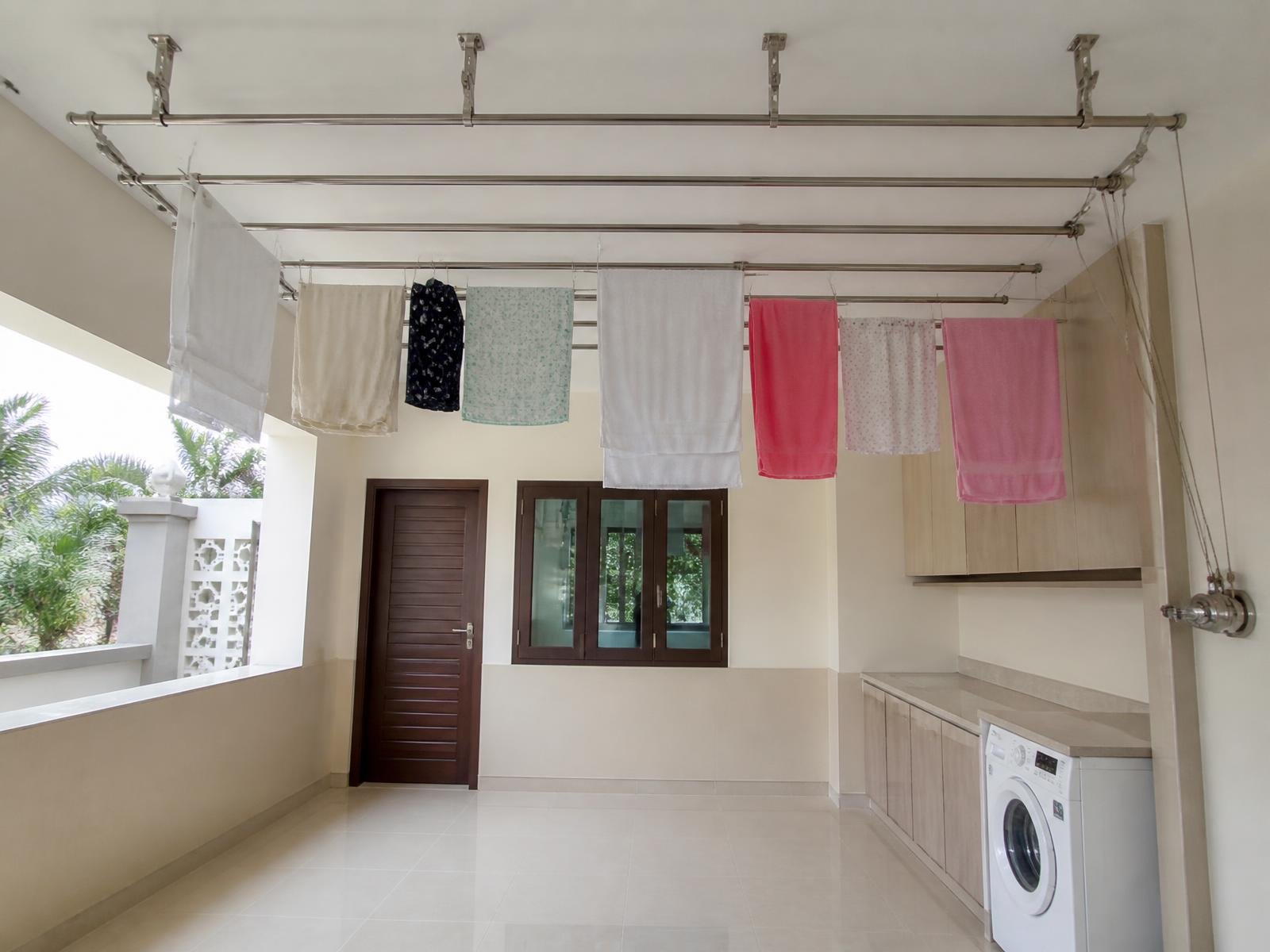 Villa utility room with a large stainless steel ceiling cloth drying hanger installed